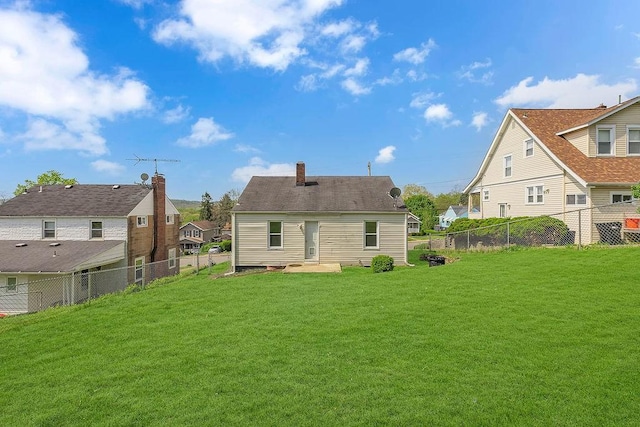 614 Grand Ave, Aliquippa, PA 15001 - back of house with a yard, a residential view, a fenced backyard, and a chimney