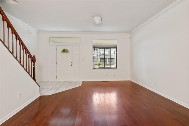 foyer featuring baseboards, stairs, hardwood / wood-style floors, and crown molding