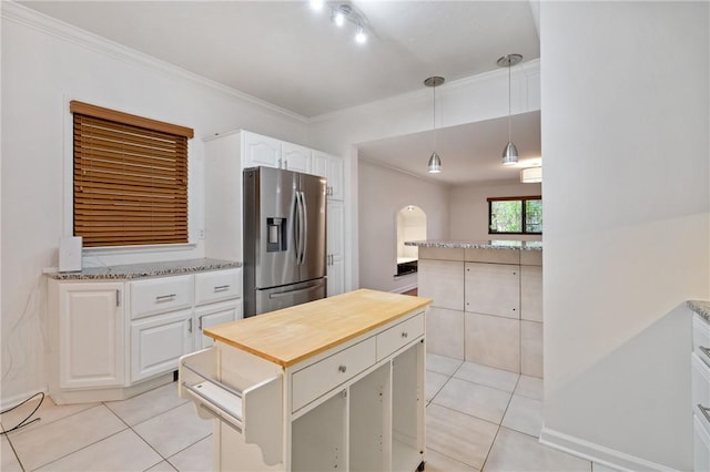 kitchen featuring pendant lighting, light tile patterned floors, wooden counters, and stainless steel refrigerator with ice dispenser