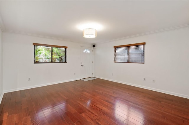 unfurnished room with crown molding, hardwood / wood-style flooring, and baseboards