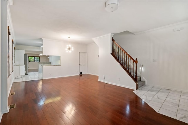 unfurnished living room with stairway, a chandelier, ornamental molding, and hardwood / wood-style floors