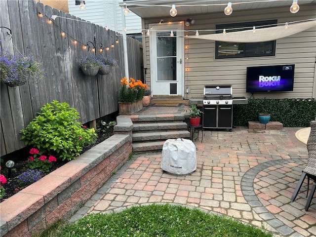 view of patio / terrace with fence and a grill