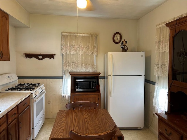 460 E Prospect Ave, City Of Washington, PA 15301 - kitchen featuring tile walls, light tile patterned floors, a wainscoted wall, light countertops, and white appliances