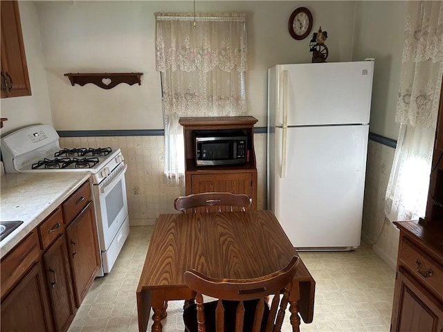 460 E Prospect Ave, City Of Washington, PA 15301 - kitchen featuring light floors, wainscoting, white appliances, and tile walls