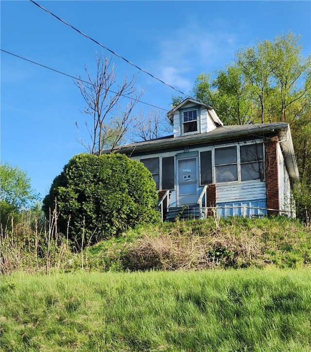 bungalow-style home with entry steps and a sunroom