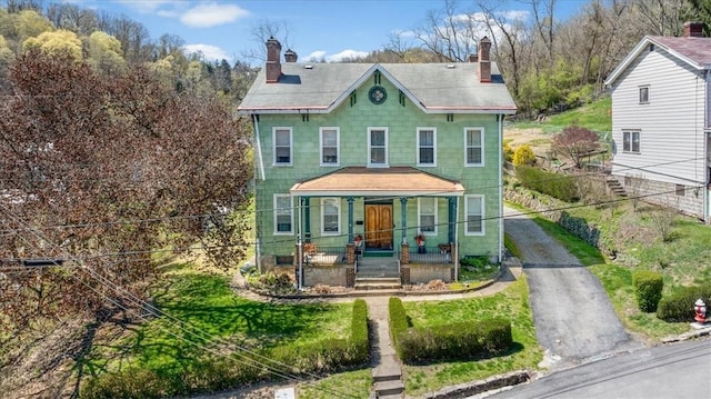 101 Clara St, Millvale, PA 15209 - view of front of house with fence, covered porch, a chimney, and aphalt driveway