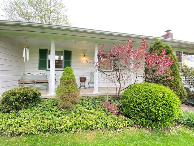 property entrance with covered porch and a chimney