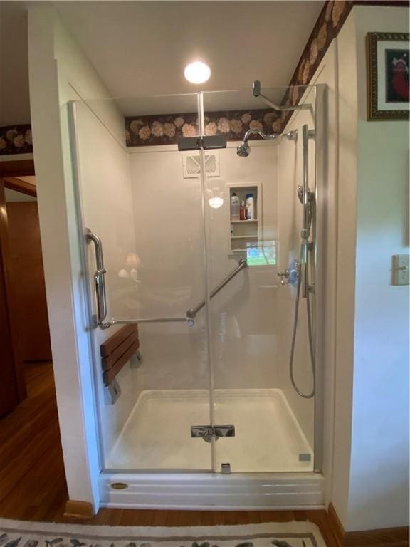 bathroom with a stall shower and wood finished floors