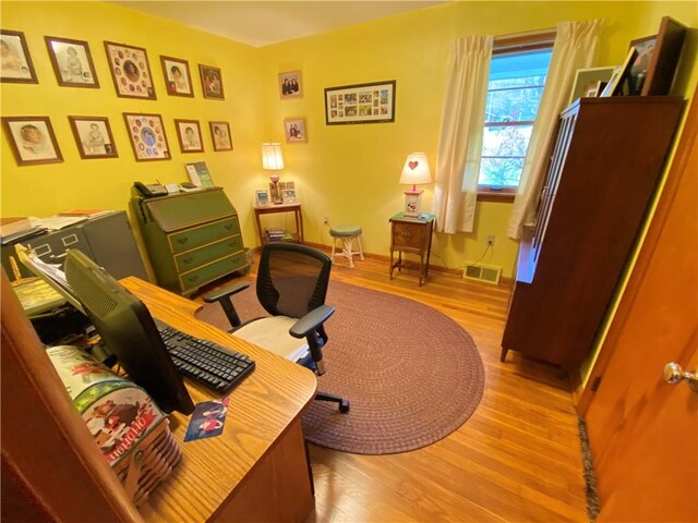 office with visible vents, baseboards, and wood finished floors