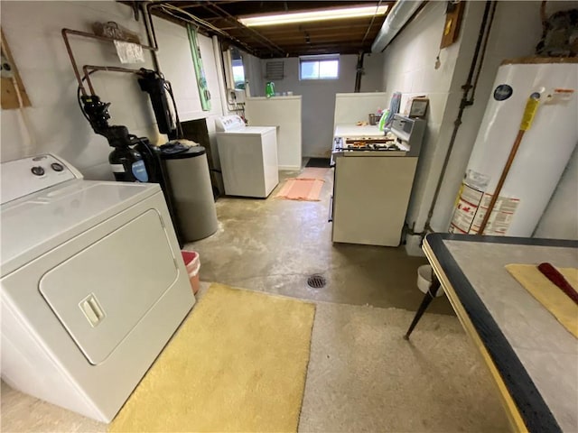 below grade area featuring washing machine and clothes dryer and water heater