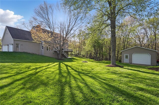 view of yard featuring a detached garage and an outbuilding