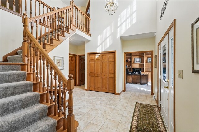 foyer entrance featuring stairs and a high ceiling