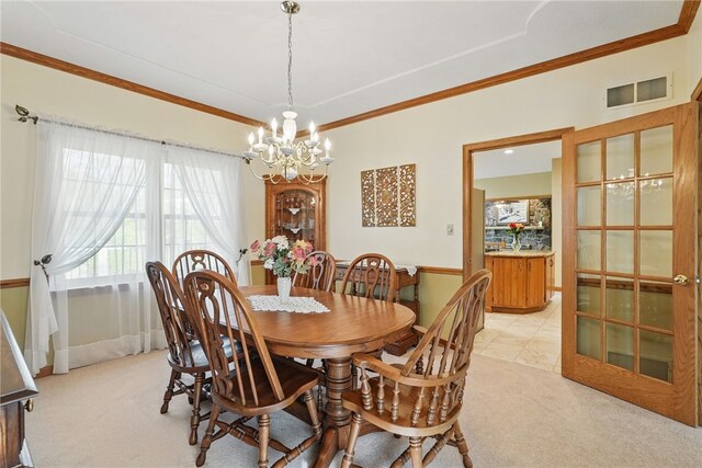 dining space featuring crown molding, a notable chandelier, light colored carpet, and visible vents