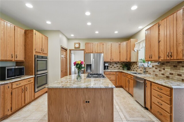 kitchen with a sink, light tile patterned floors, a kitchen island, and stainless steel appliances