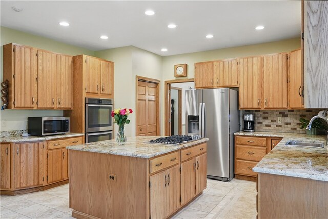 kitchen featuring a kitchen island, recessed lighting, light stone counters, a sink, and stainless steel appliances