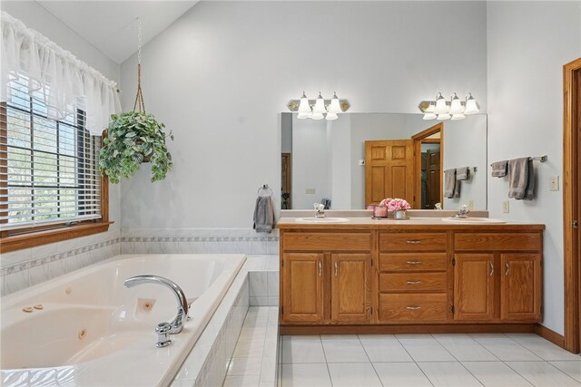 full bath featuring a sink, double vanity, tile patterned floors, a tub with jets, and vaulted ceiling