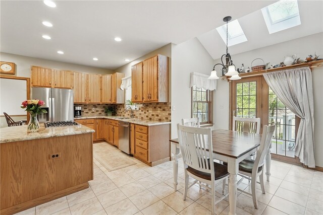kitchen featuring an inviting chandelier, decorative backsplash, recessed lighting, light stone counters, and stainless steel appliances