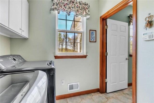 washroom with visible vents, cabinet space, light tile patterned floors, baseboards, and separate washer and dryer