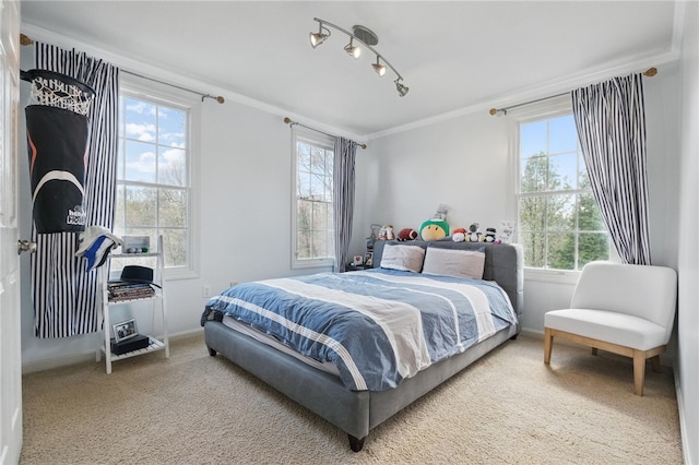 carpeted bedroom with baseboards, ornamental molding, multiple windows, and rail lighting
