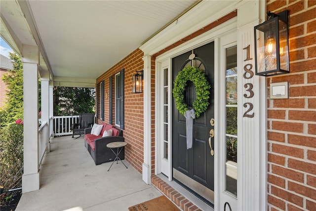 doorway to property with covered porch and brick siding
