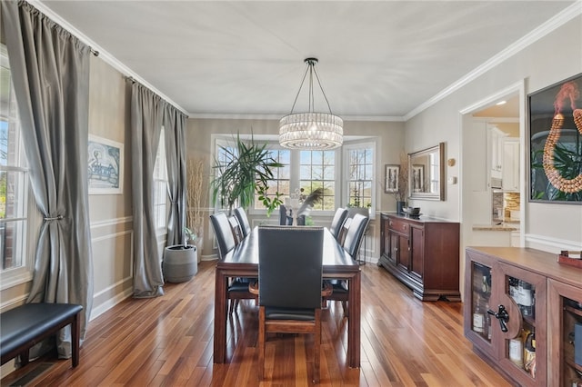 dining room with crown molding, a chandelier, and hardwood / wood-style floors
