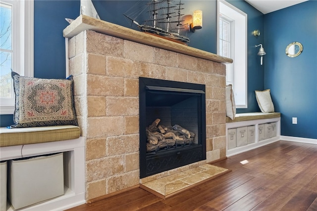 details with baseboards, wood finished floors, and a tile fireplace