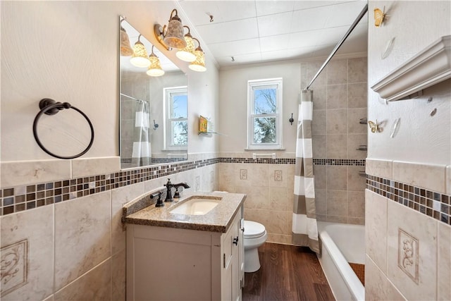 413 Pasadena Dr, Port Vue, PA 15133 - bathroom with crown molding, tile walls, wood finished floors, vanity, and shower / bath combo with shower curtain