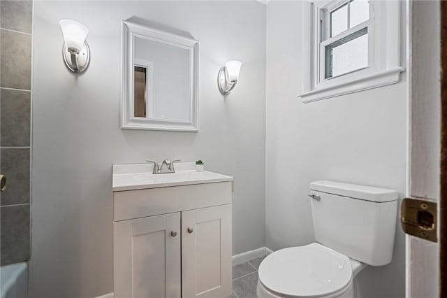 bathroom featuring vanity, a shower, toilet, baseboards, and tile patterned floors