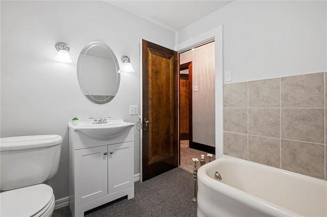 bathroom featuring vanity, toilet, and a tub to relax in