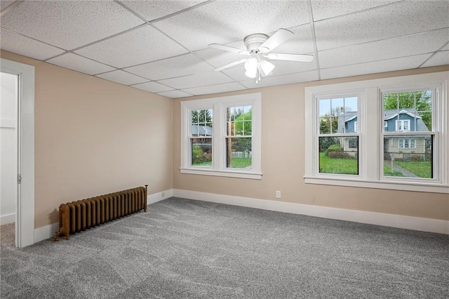 unfurnished room with carpet floors, radiator heating unit, and a healthy amount of sunlight