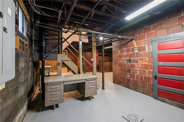 unfinished below grade area featuring brick wall and stairway