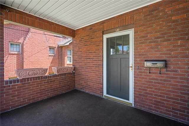 view of exterior entry featuring brick siding