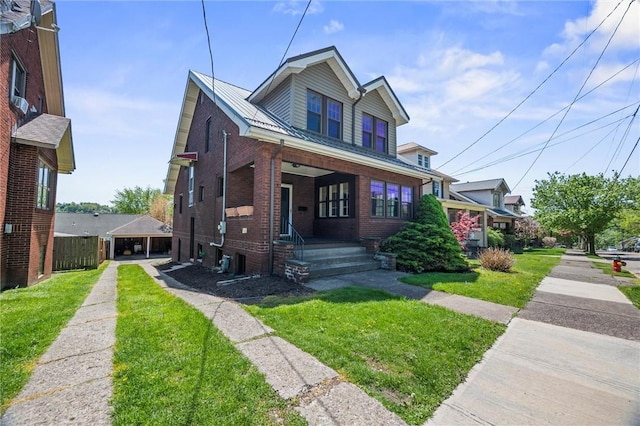 bungalow-style home with covered porch, brick siding, and a front yard