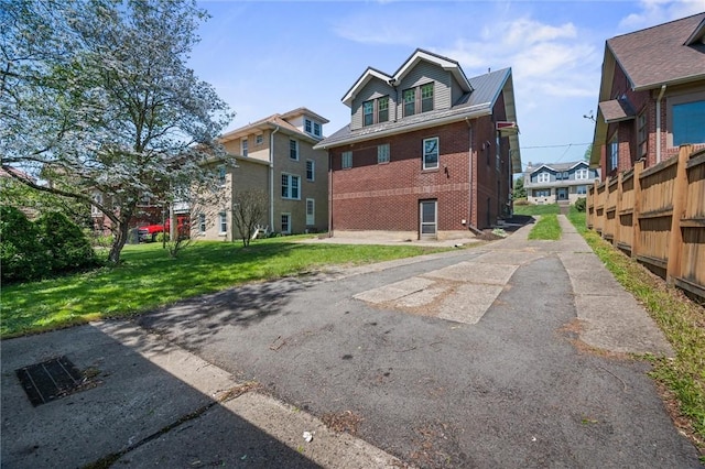 exterior space with brick siding and a yard