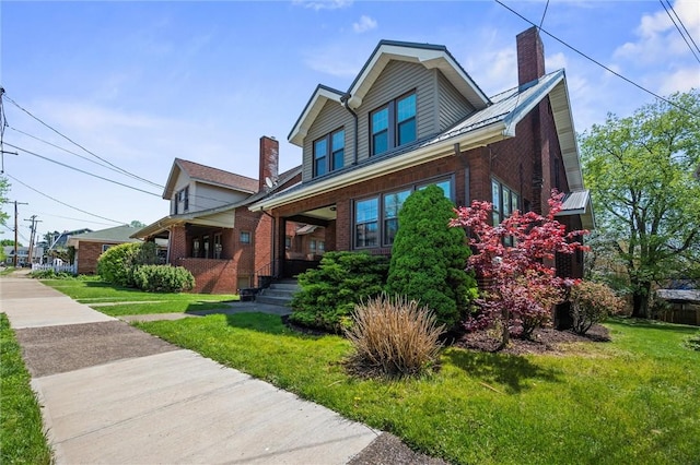 view of front of property with brick siding, a front yard, and a chimney