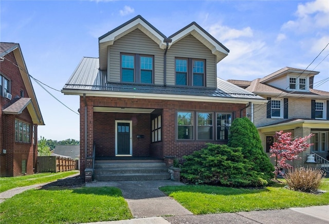view of front facade featuring fence, brick siding, a standing seam roof, covered porch, and metal roof