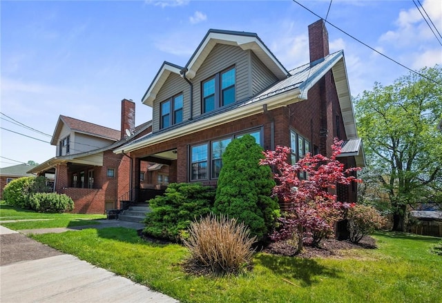 craftsman inspired home with brick siding, a front lawn, covered porch, and a chimney