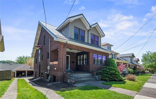 view of front of home featuring a porch, a front yard, a garage, brick siding, and fence