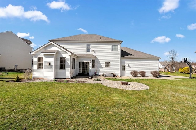 rear view of house with a lawn and an outdoor fire pit