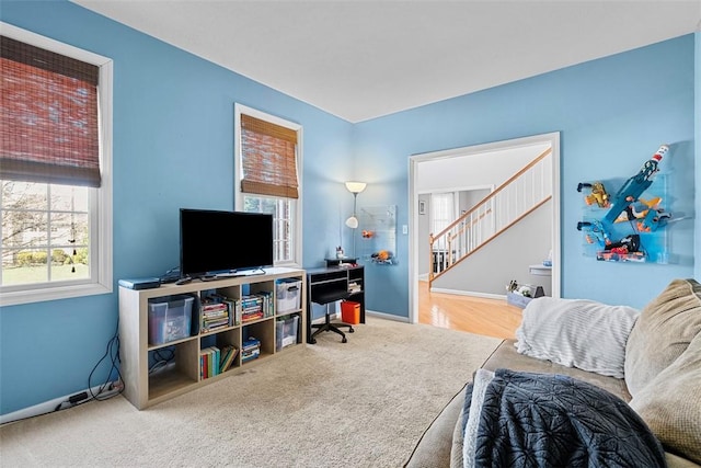 interior space featuring carpet flooring, baseboards, and stairway