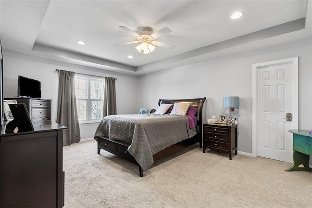bedroom with a raised ceiling, baseboards, light carpet, and recessed lighting