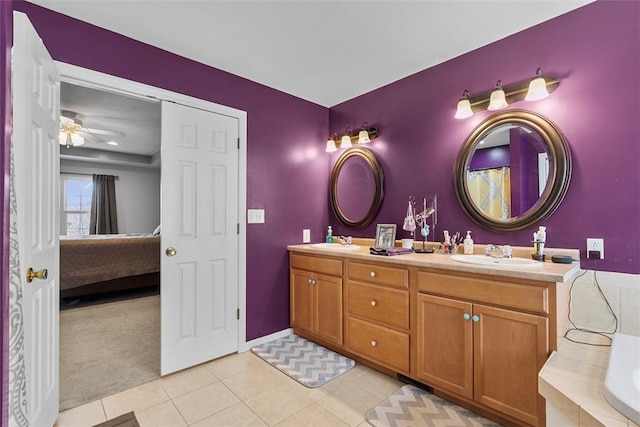 ensuite bathroom with a sink, tile patterned floors, ensuite bath, and double vanity