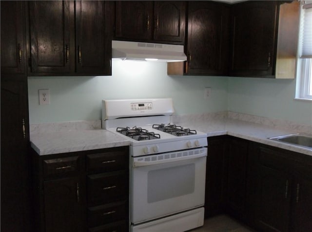 419 Streets Run Rd, Whitehall, PA 15236 - kitchen featuring light countertops, white gas stove, under cabinet range hood, and dark brown cabinetry