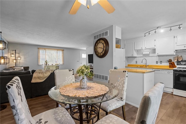 dining space featuring visible vents, ceiling fan, and wood finished floors