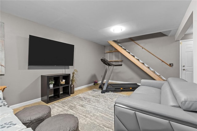 living area with baseboards and stairway