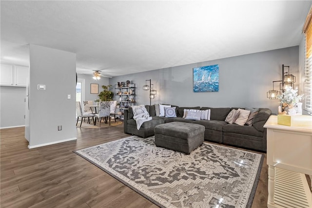 living area with baseboards, a ceiling fan, and wood finished floors