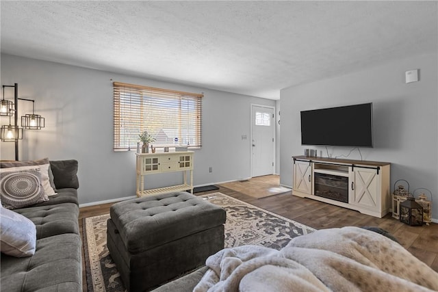 living room with baseboards, a textured ceiling, and wood finished floors