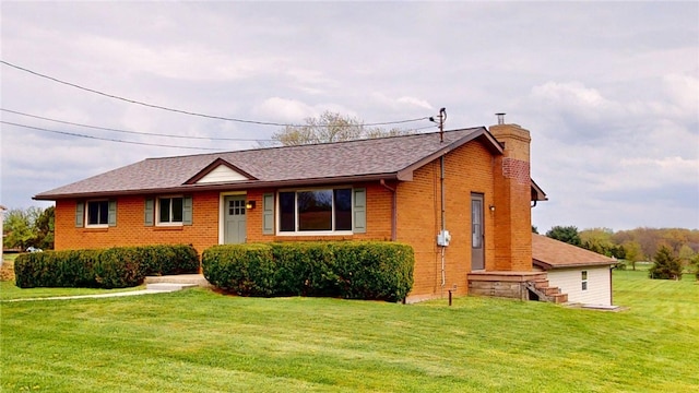 ranch-style house with brick siding, a chimney, roof with shingles, and a front lawn