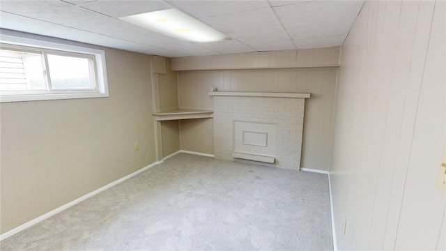 basement with carpet floors, baseboards, and wood walls