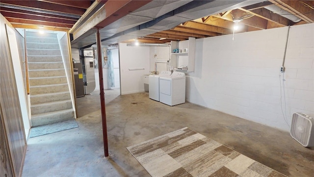 unfinished below grade area featuring washing machine and dryer and stairway